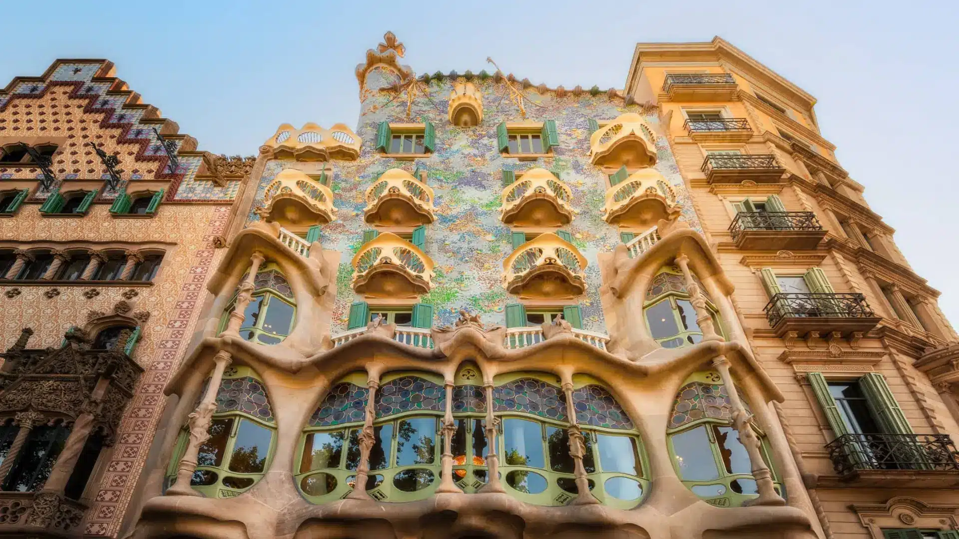 A building covered in a mosaic of bright, colorful tiles, showcasing artistic design