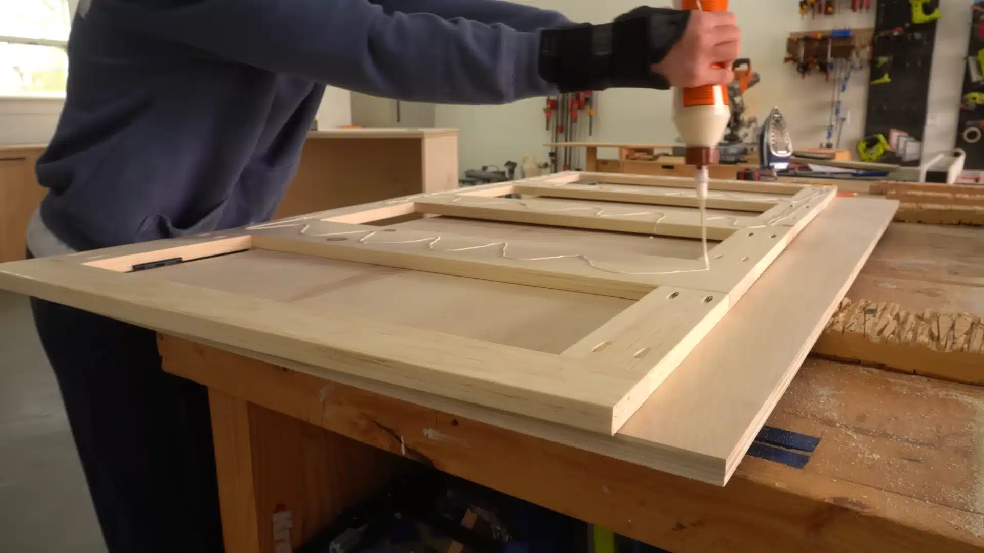 Gluing and assembling backer panel with frame pieces for Murphy bed door section on workbench