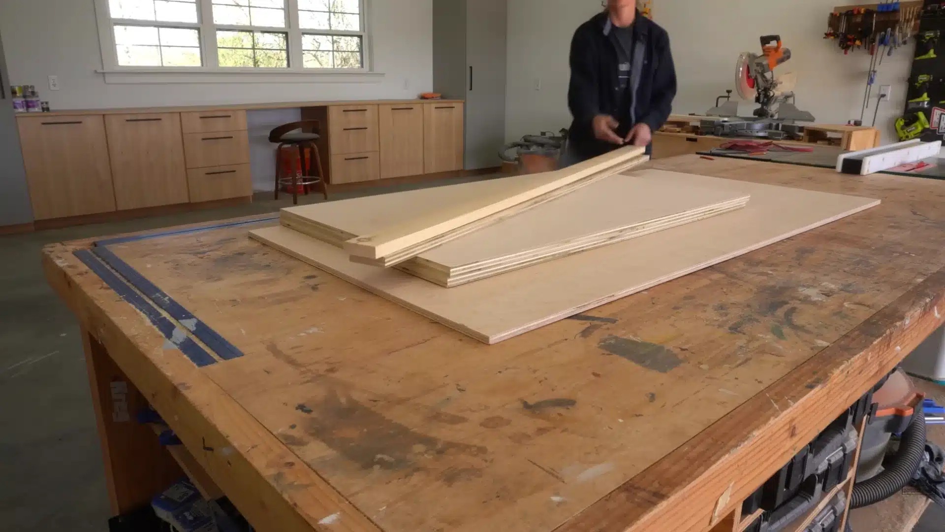 Wood panels and boards arranged on workbench before assembling main cabinet frame for Murphy bed project