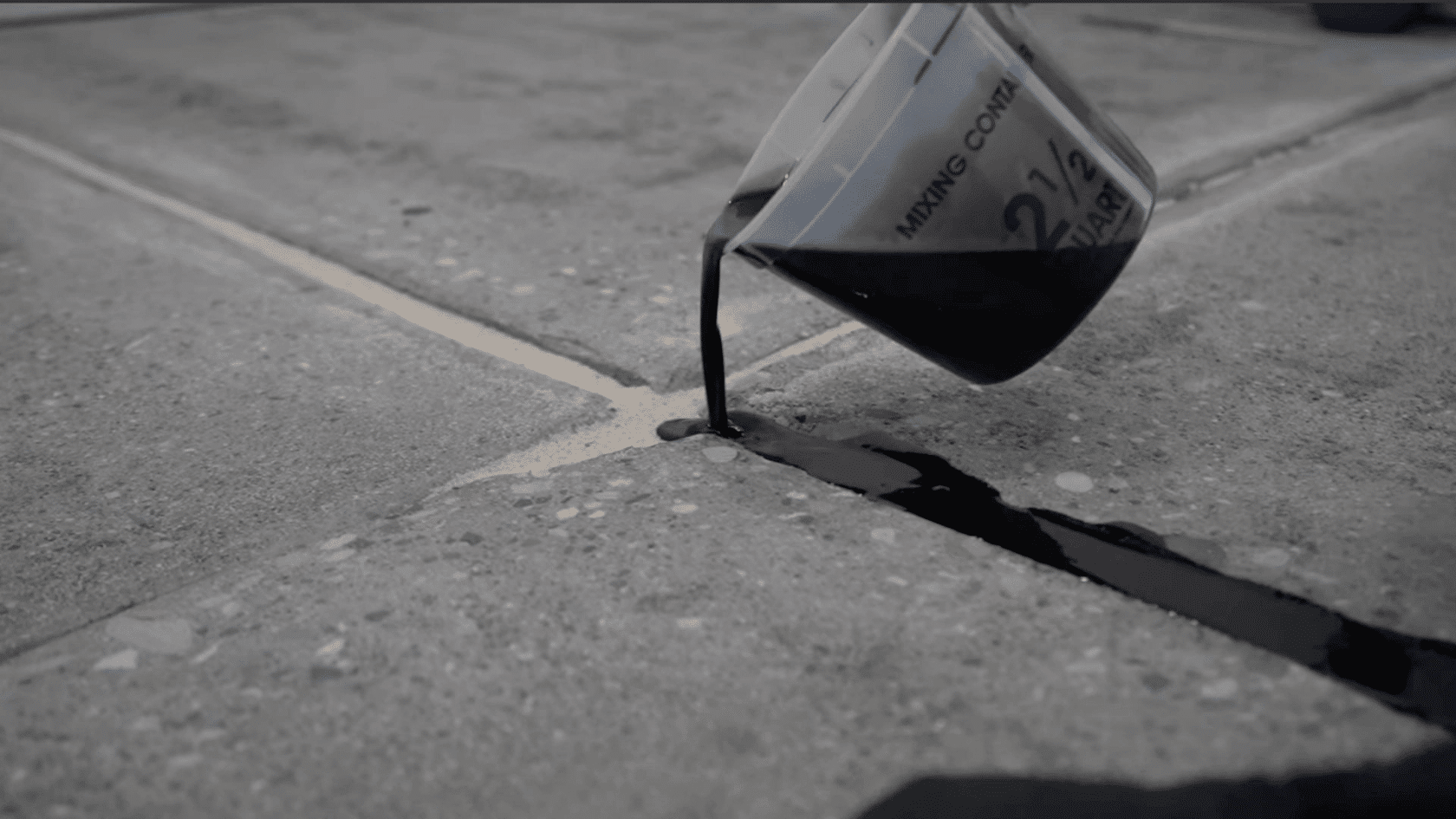 concrete crack filled with repair compound after applying crack repair product over silica sand.