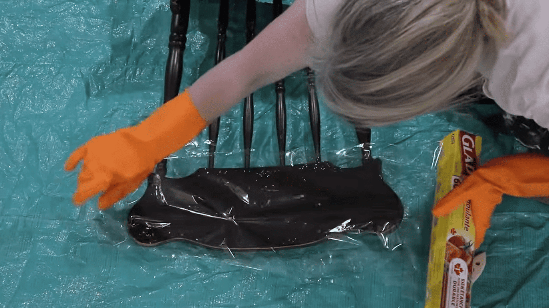 Covering paint stripper on wood furniture with plastic wrap to keep it active