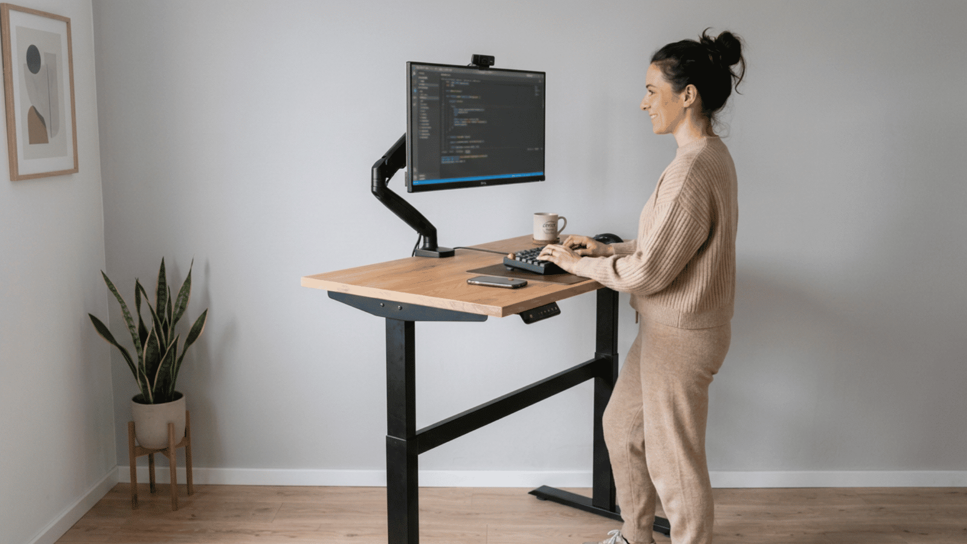 Person using a standing desk with monitor at proper height for work