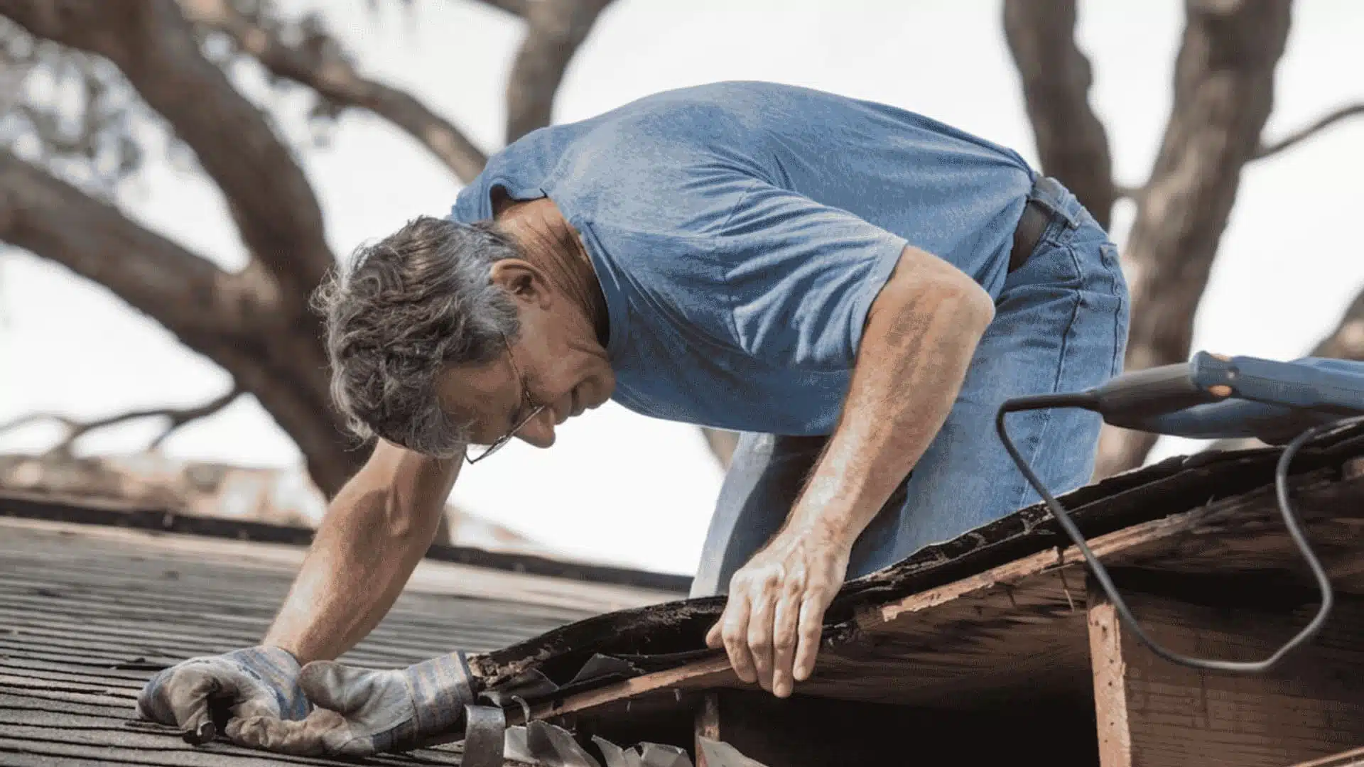 Man in blue t-shirt performing a professional roof fix