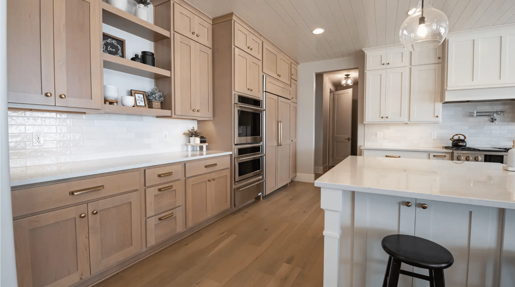 modern kitchen with flat-panel wood cabinets, white island, and muted neutral finishes.