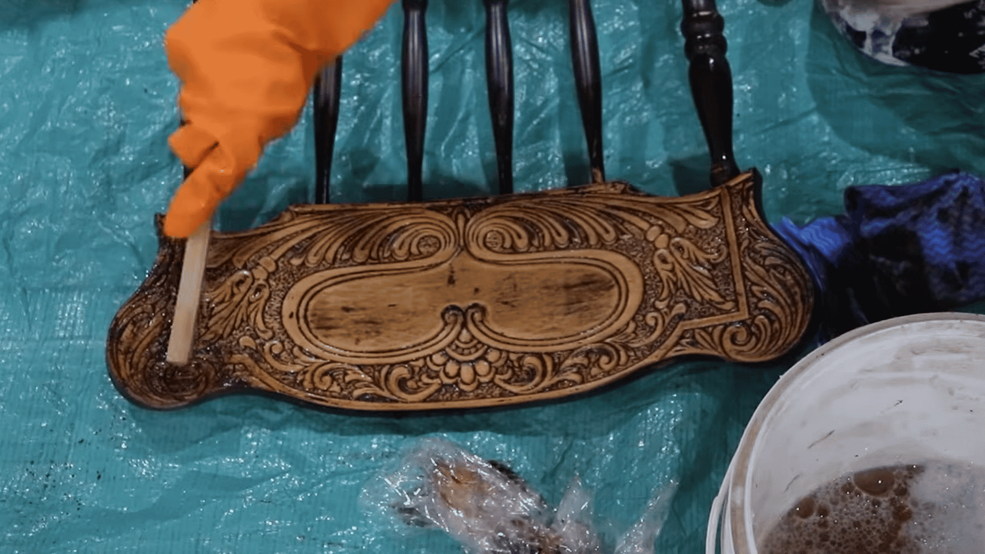 Applying additional paint stripper to remove paint from hard-to-reach furniture grooves