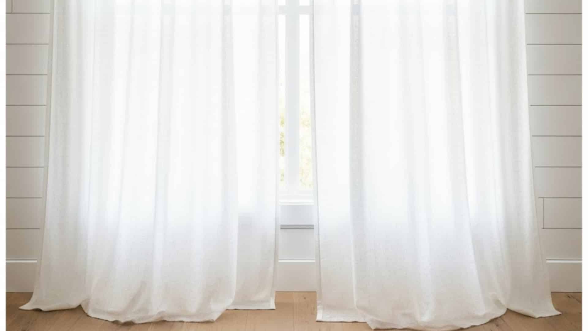 floor-length sheer white curtains filtering sunlight into a bright room